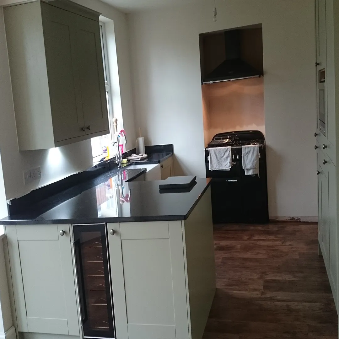 neutral green shaker style kitchen with black granite benchtop